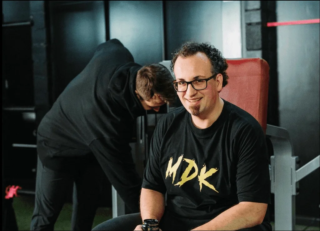 Klant in MDK-shirt tijdens een van zijn eerste sessies, de coach stelt het toestel in
