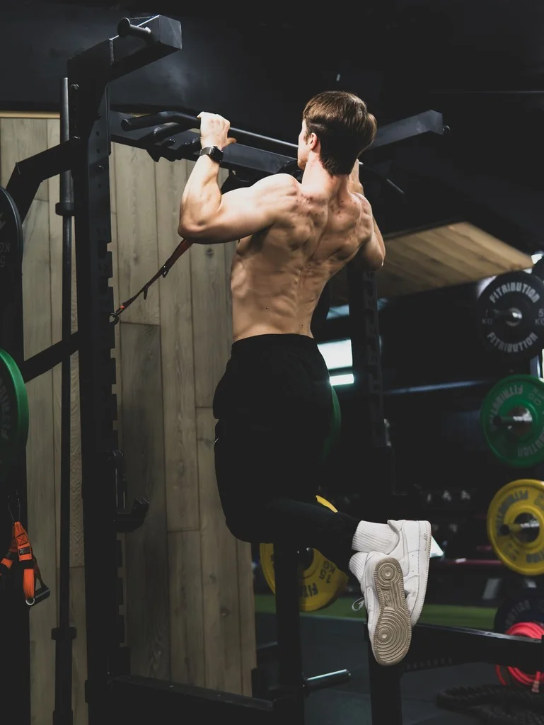 Man doet een pull-up, van achteren gezien
